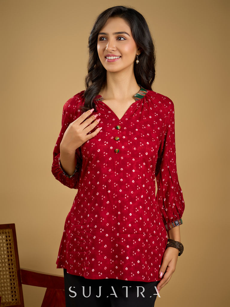 Red rayon bandhani top beautifully combined with classic ikat collar.