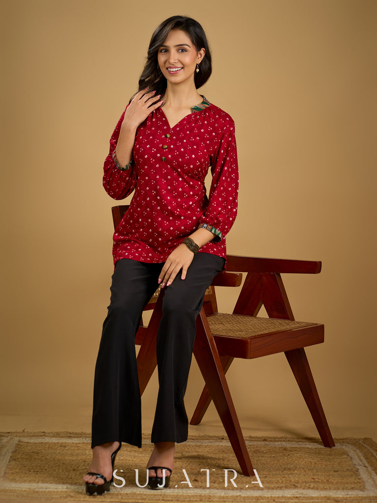Red rayon bandhani top beautifully combined with classic ikat collar.