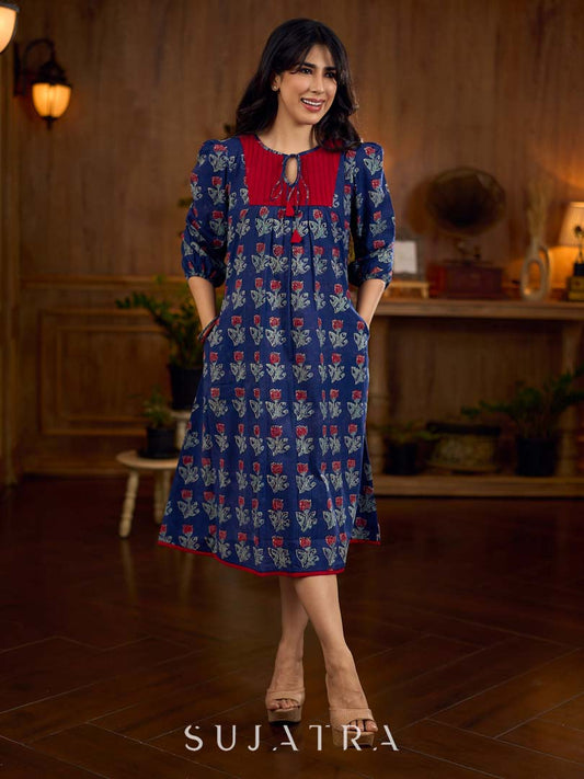 Royal blue Jaipur-printed dress featuring red rose motifs, a pintuck neck patch with red accents, and balloon 3/4th sleeves, creating a graceful silhouette with a blend of artisanal charm and contemporary elegance.