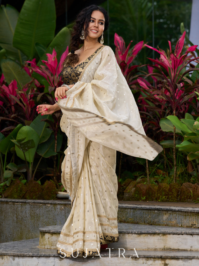Timeless ivory tissue saree featuring zari embroidery and Banarasi accents