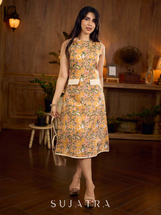 Summery mustard and peach floral sleeveless dress featuring a boat neckline and Hakoba pocket detailing, finished with soft off-white accents for a breezy, cheerful silhouette perfect for warm days.