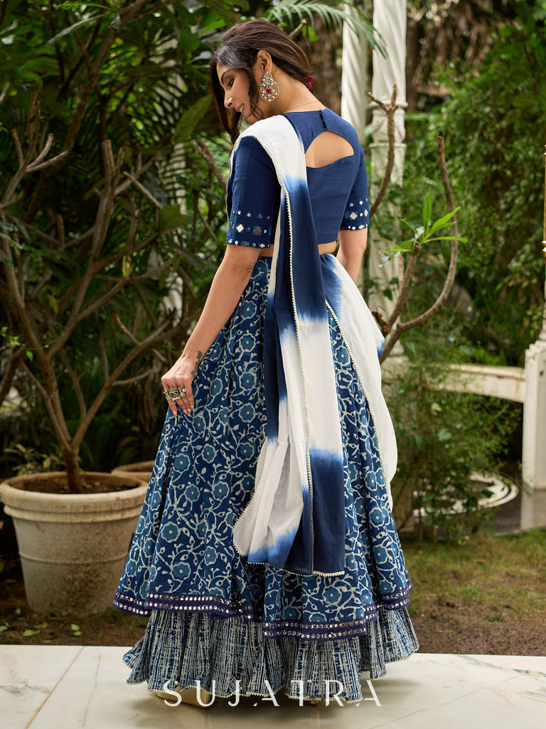 Modern folkloric layered indigo lehenga beautifully contrasted with a luminous full mirror work choli - Lehriya dupatta optional.