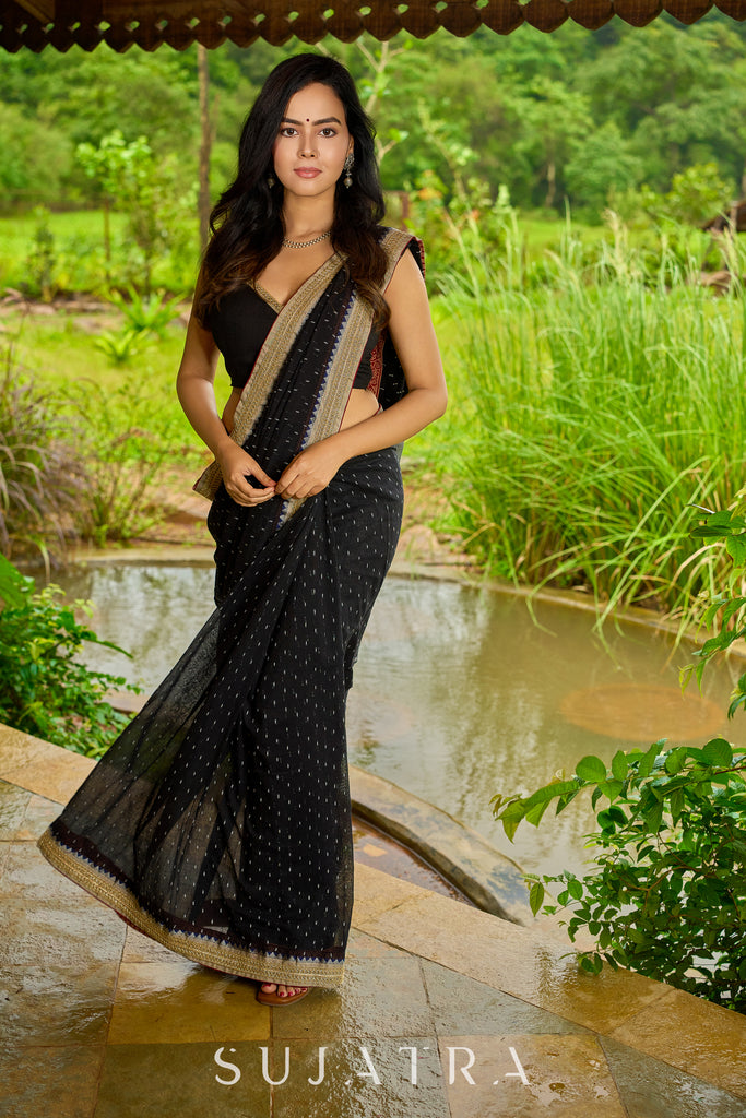 Classic black cotton saree featuring intricate weave and radiant zari edges
