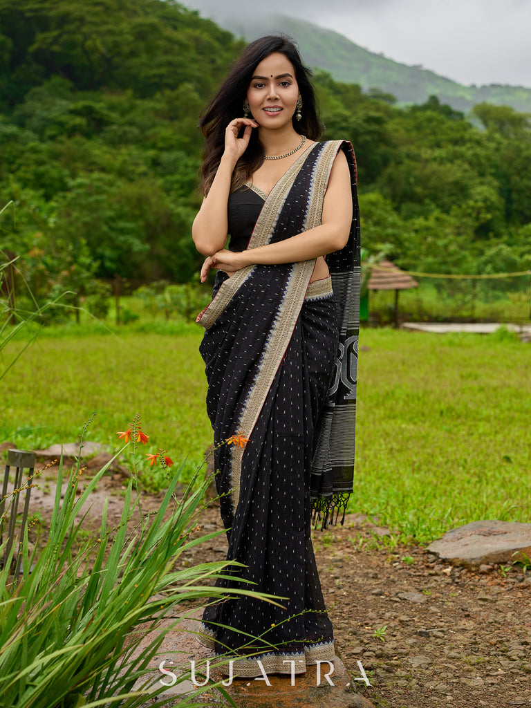 Classic black cotton saree featuring intricate weave and radiant zari edges