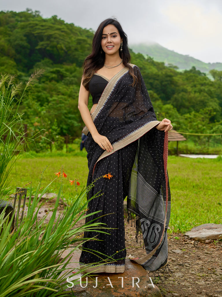Classic black cotton saree featuring intricate weave and radiant zari edges