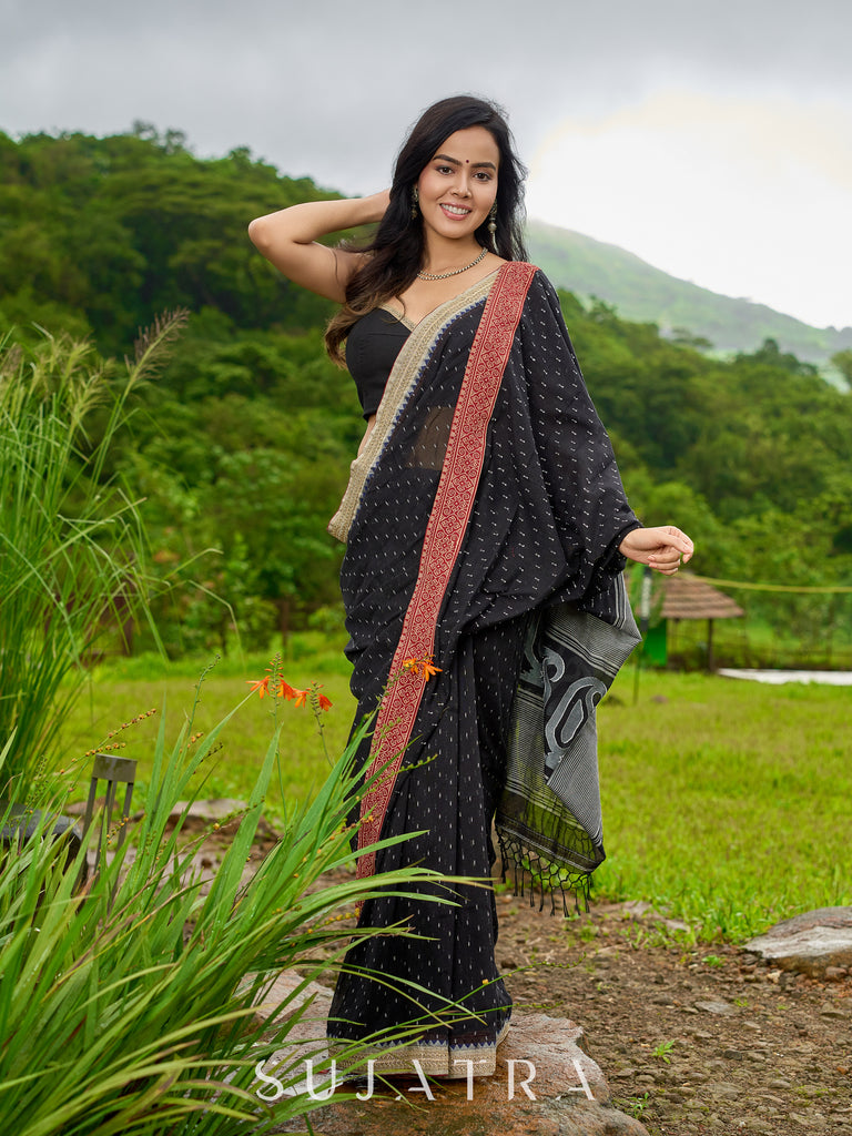 Classic black cotton saree featuring intricate weave and radiant zari edges