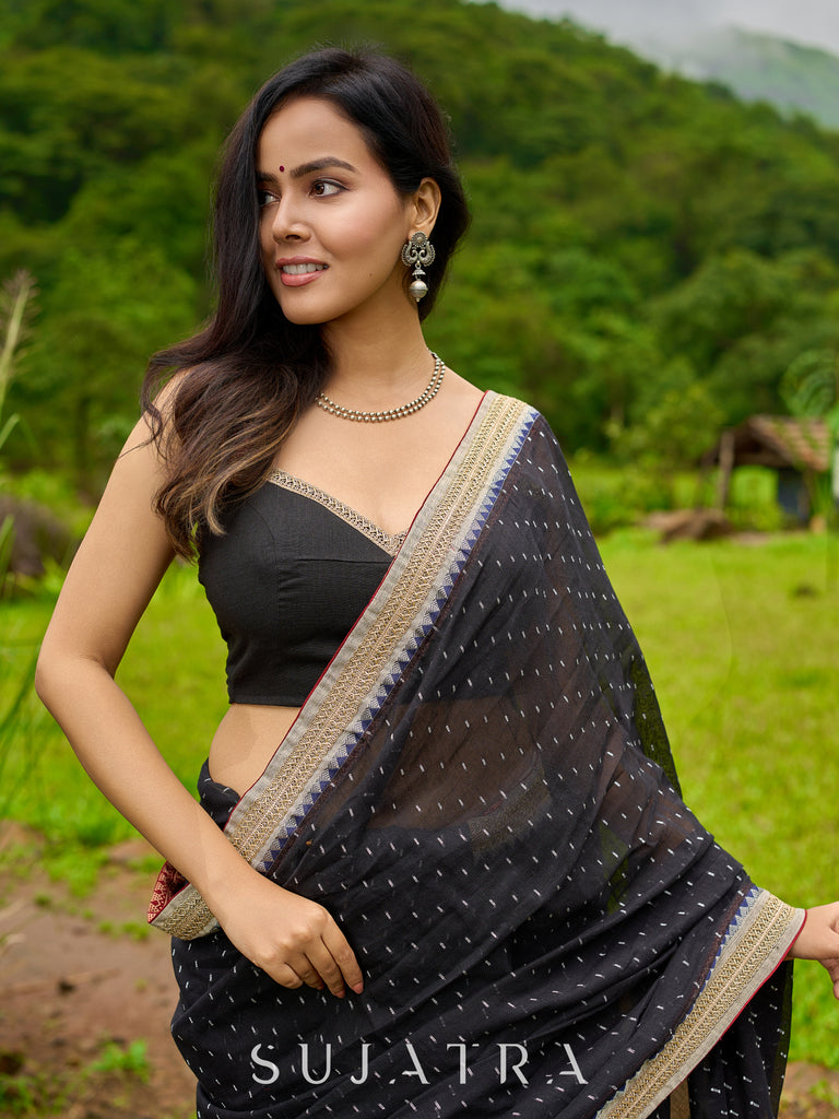 Classic black cotton saree featuring intricate weave and radiant zari edges