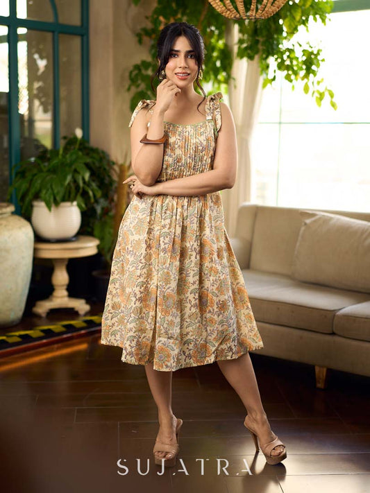 Peach floral strappy dress featuring a front tie-up bow with centre pintuck detailing, creating soft structure and a flowy, feminine silhouette perfect for effortless summer styling.