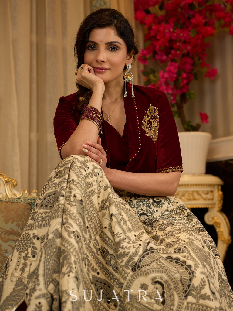 Madhubani print lehenga with a scalloped hem, paired with a rich maroon velvet blouse - Short Jacket with elegant brooch style embroidery Optional