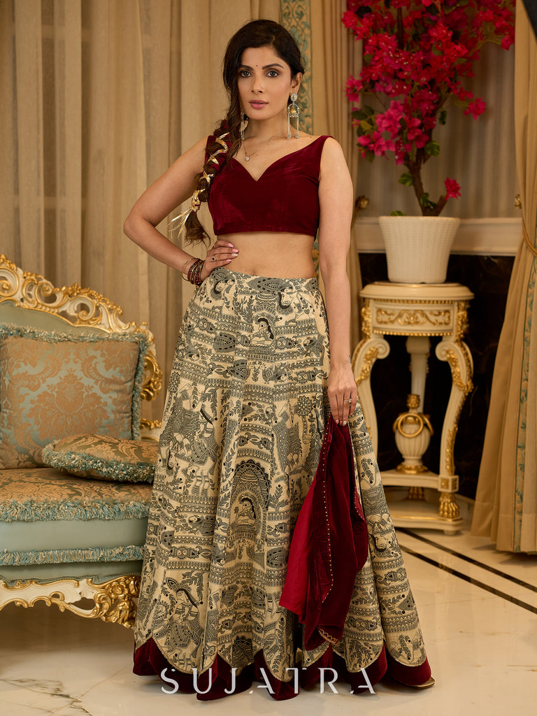 Madhubani print lehenga with a scalloped hem, paired with a rich maroon velvet blouse - Short Jacket with elegant brooch style embroidery Optional