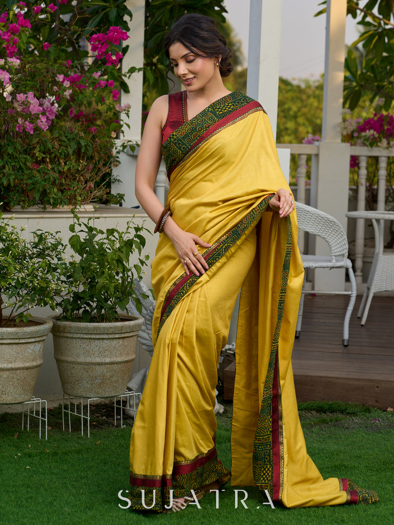 Vibrant yellow silk mix saree with hand block printed Ajrakh border