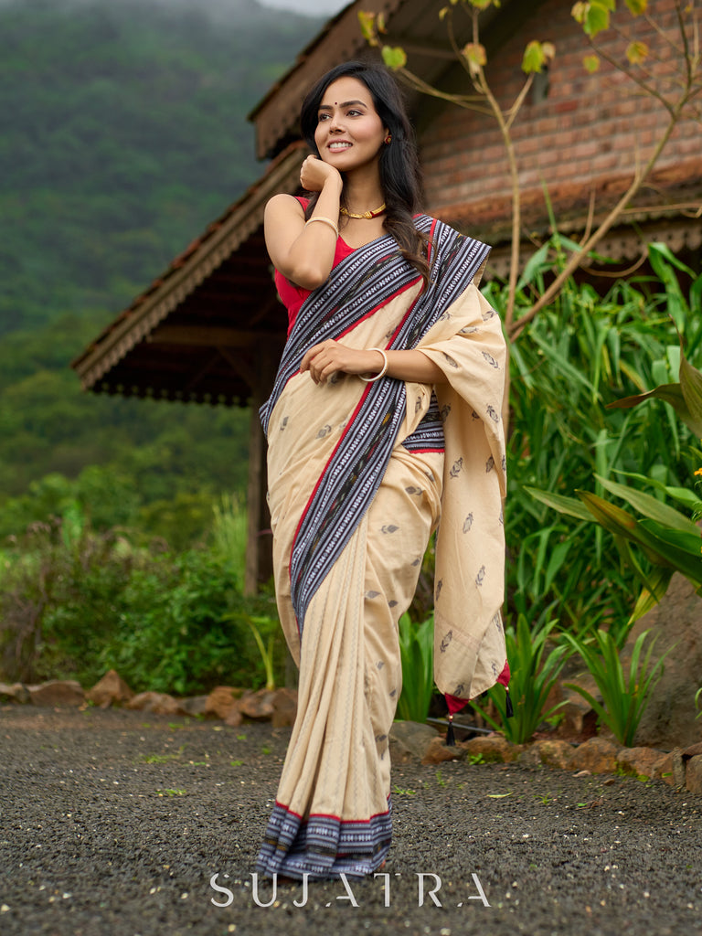 Beige cotton saree enriched with traditional Ikat border and Jamdani accents