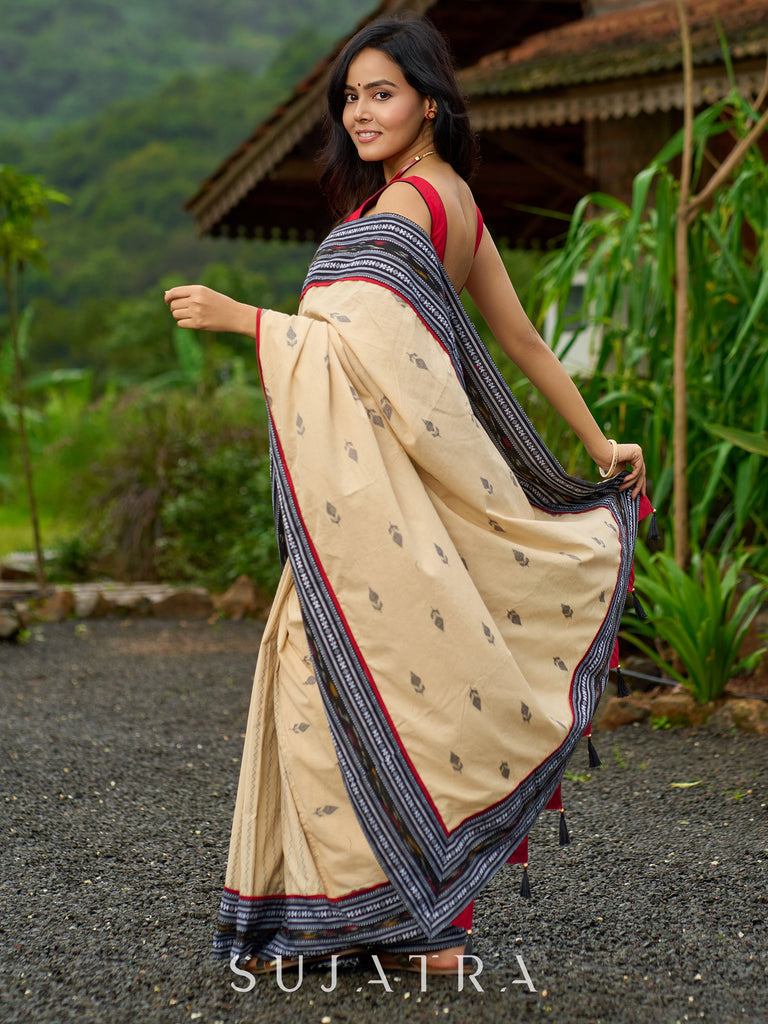 Beige cotton saree enriched with traditional Ikat border and Jamdani accents