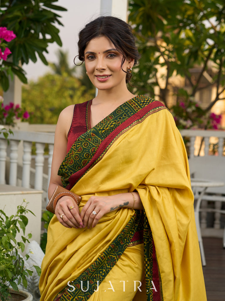 Vibrant yellow silk mix saree with hand block printed Ajrakh border