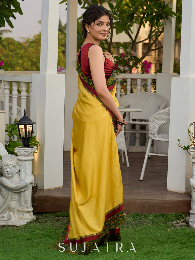 Vibrant yellow silk mix saree with hand block printed Ajrakh border
