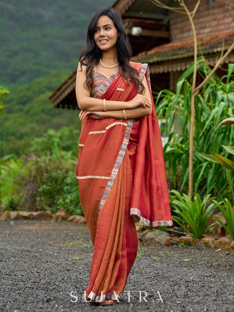 Luxury burnt orange tissue saree adorned with shimmering zari highlights