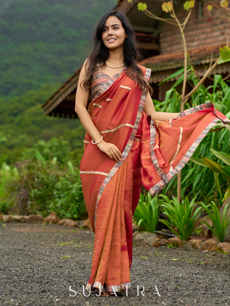 Luxury burnt orange tissue saree adorned with shimmering zari highlights