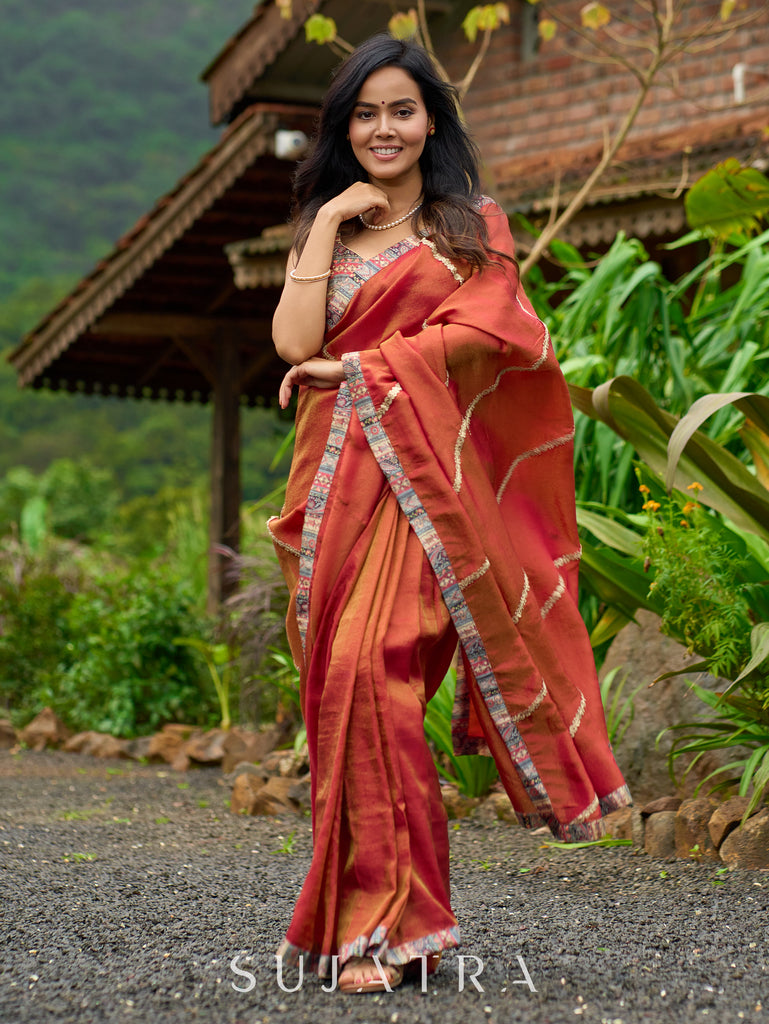 Luxury burnt orange tissue saree adorned with shimmering zari highlights