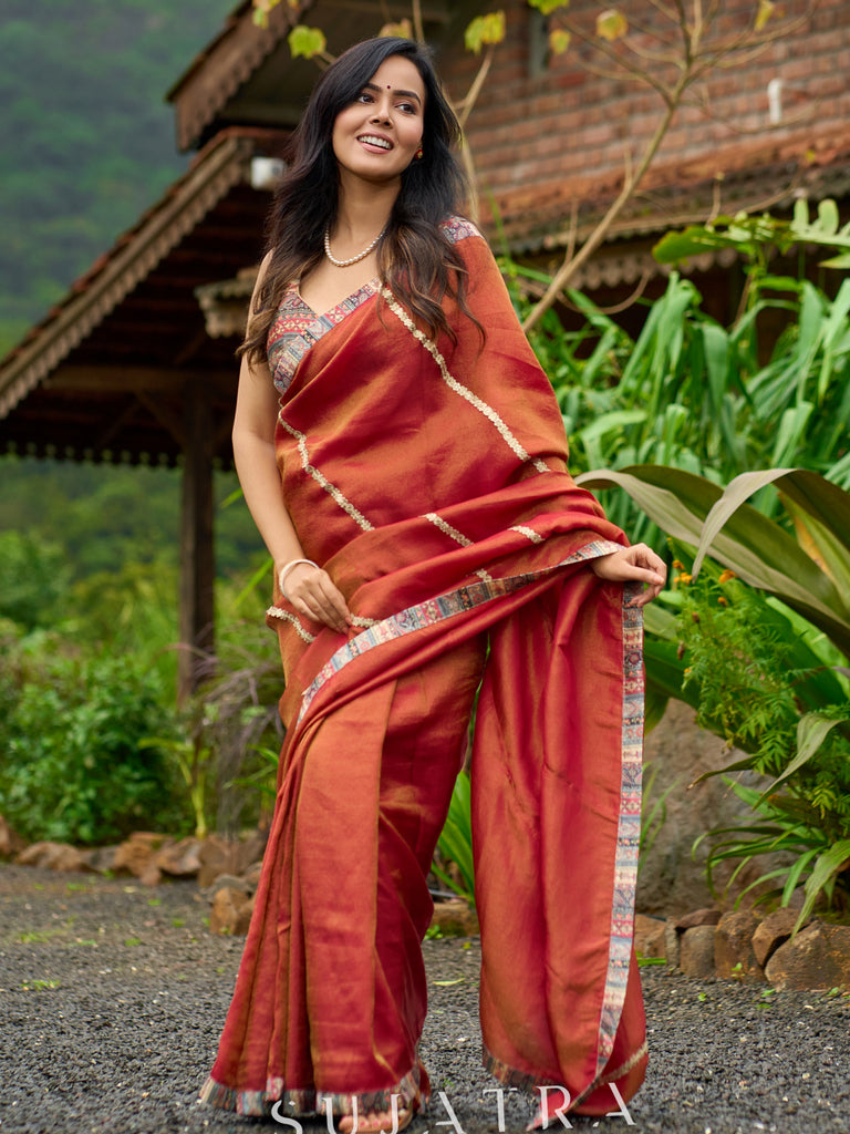 Luxury burnt orange tissue saree adorned with shimmering zari highlights