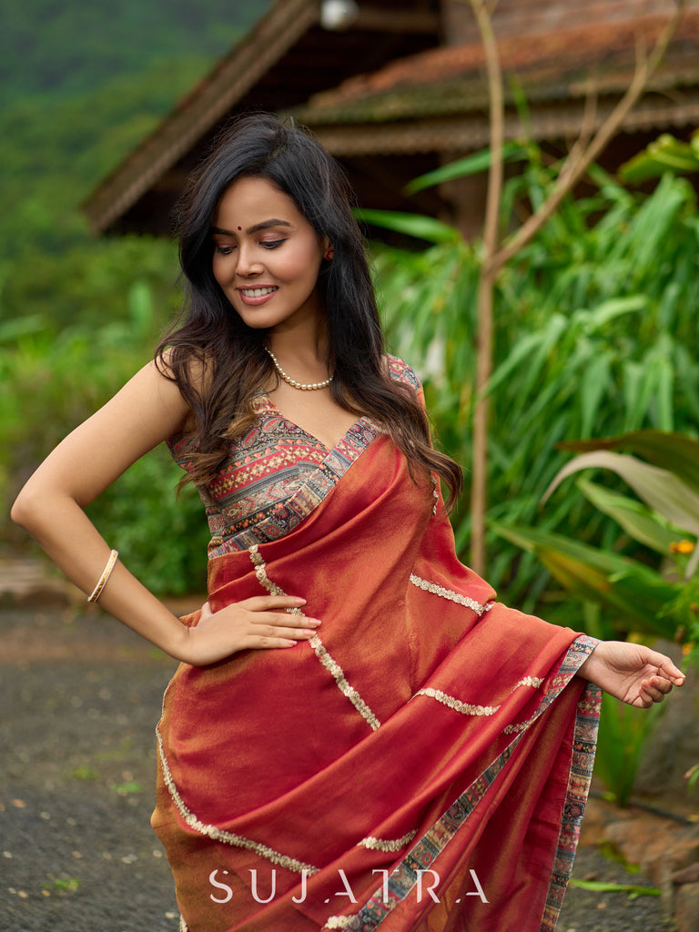Luxury burnt orange tissue saree adorned with shimmering zari highlights