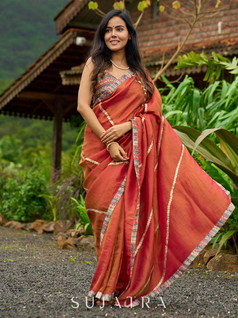 Luxury burnt orange tissue saree adorned with shimmering zari highlights
