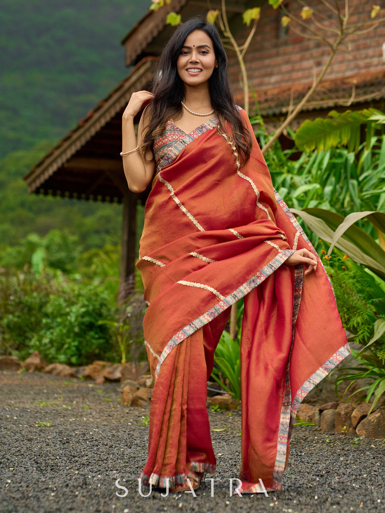 Luxury burnt orange tissue saree adorned with shimmering zari highlights