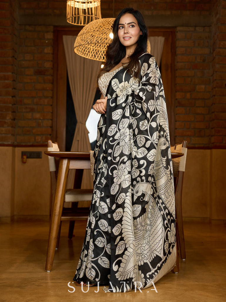 Artisanal black silk saree featuring intricate hand-drawn Kalamkari style motifs