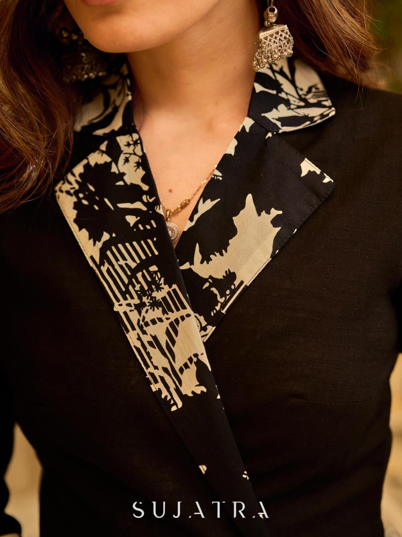 Chic black overlapping blazer-style wrap dress featuring printed black-and-white collar, cuffs, tie detail, and subtle accents