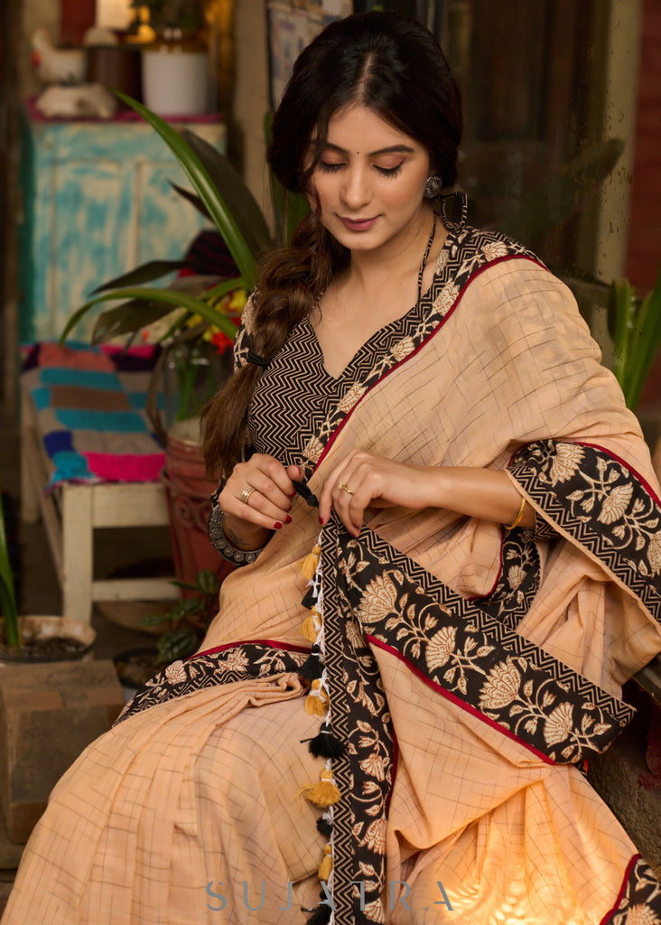 Elegant pastel peach cotton saree highlighted with beautiful floral border