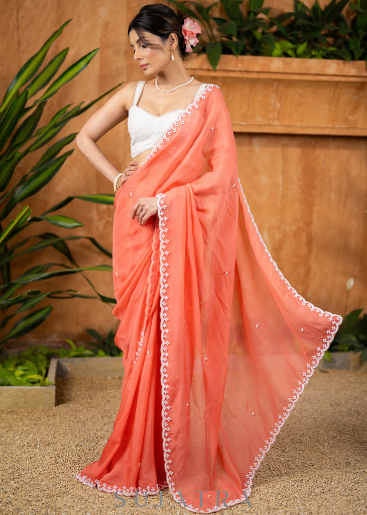 Stylish Apricot Peach Organza Saree Highlighted With Overall Hand Embroidered Pearls