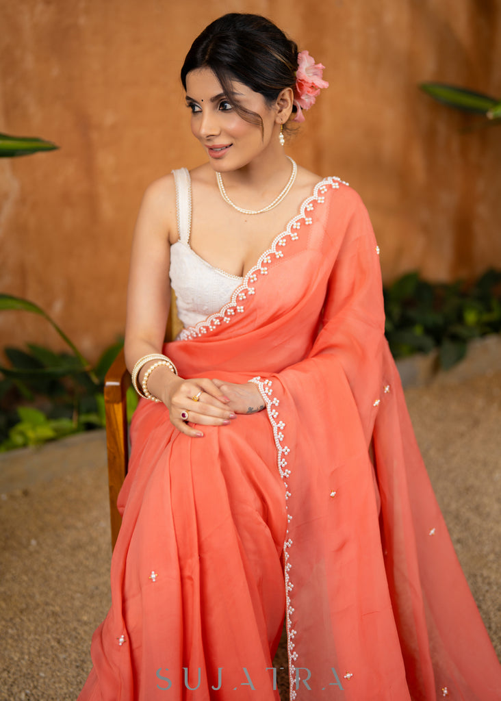 Stylish Apricot Peach Organza Saree Highlighted With Overall Hand Embroidered Pearls