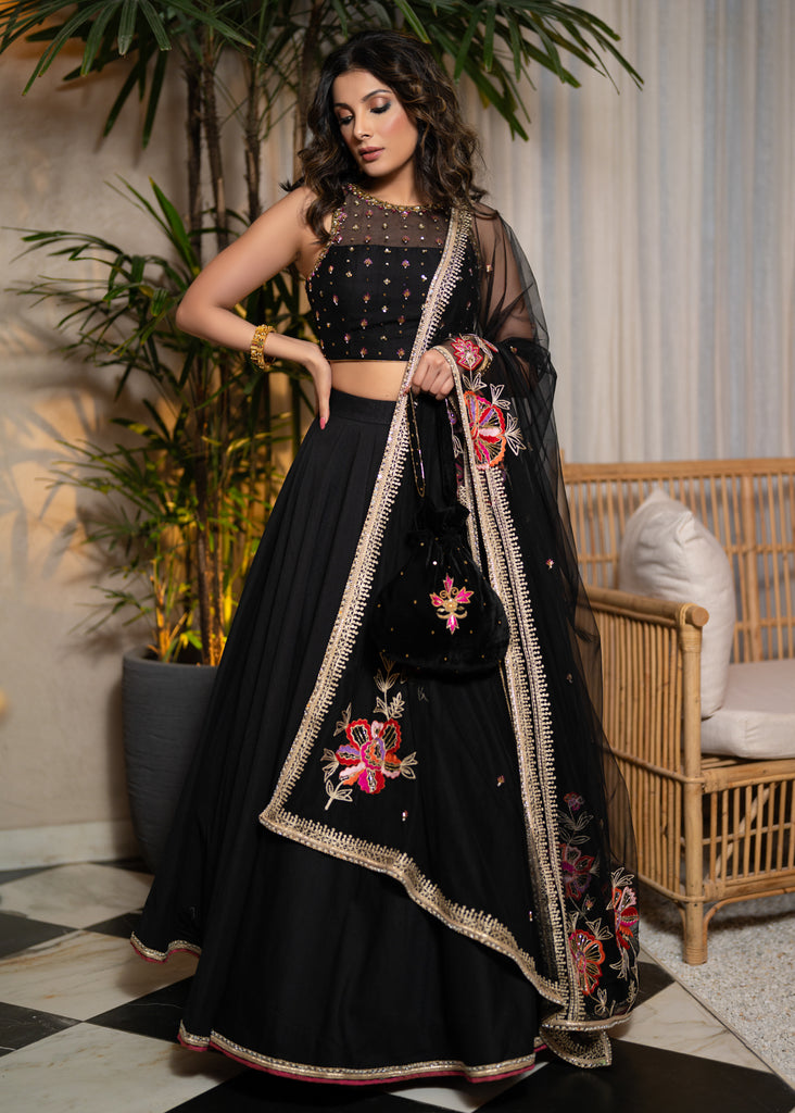 Classic Black Cotton Silk Lehenga paired with delicately embellished net dupatta accentuated with heavy floral embroidery and hand embellishments