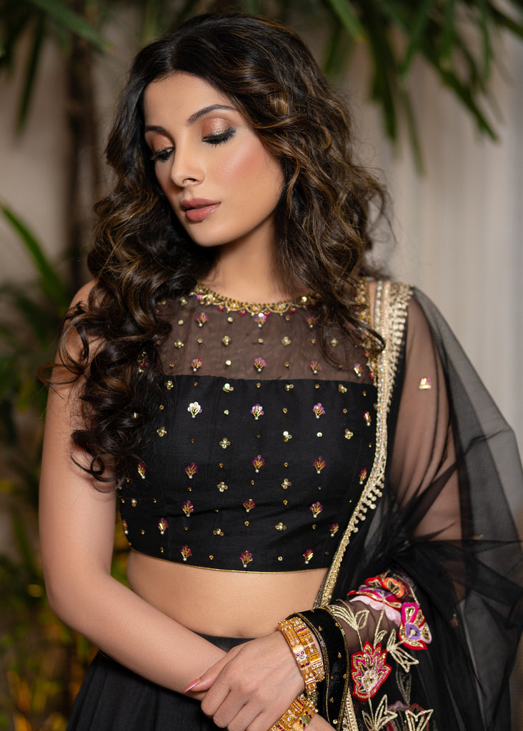 Classic Black Cotton Silk Lehenga paired with delicately embellished net dupatta accentuated with heavy floral embroidery and hand embellishments