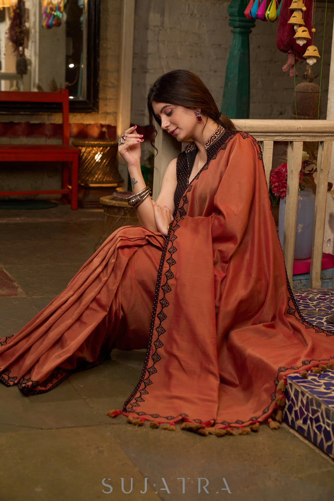 Graceful rust cotton plain saree highlighted with overall ajrakh applique border