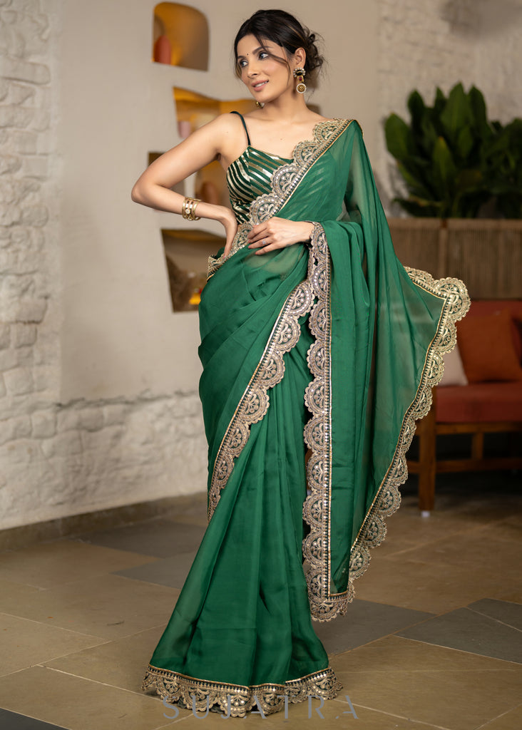 Graceful Bottle Green Organza Saree Highlighted With Matching Scalloped Lace