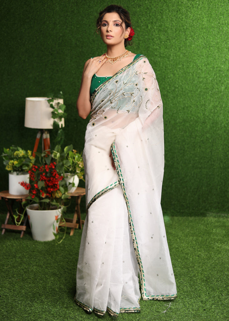 Elegant white saree with delicate hand-embroidery and green Banasari border