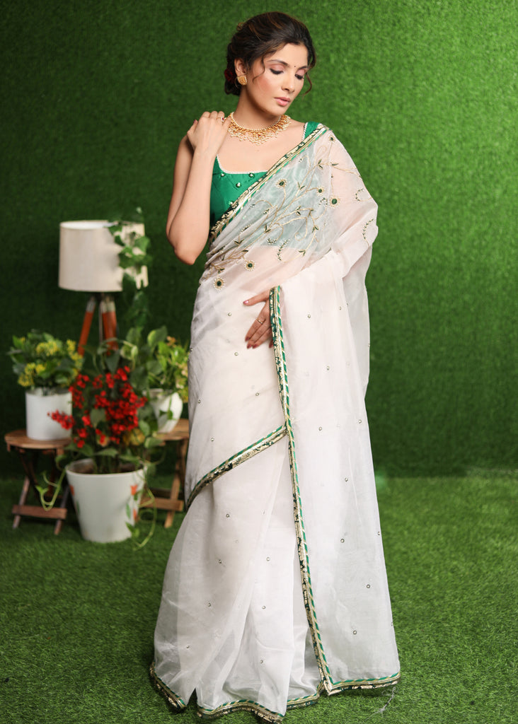 Elegant white saree with delicate hand-embroidery and green Banasari border