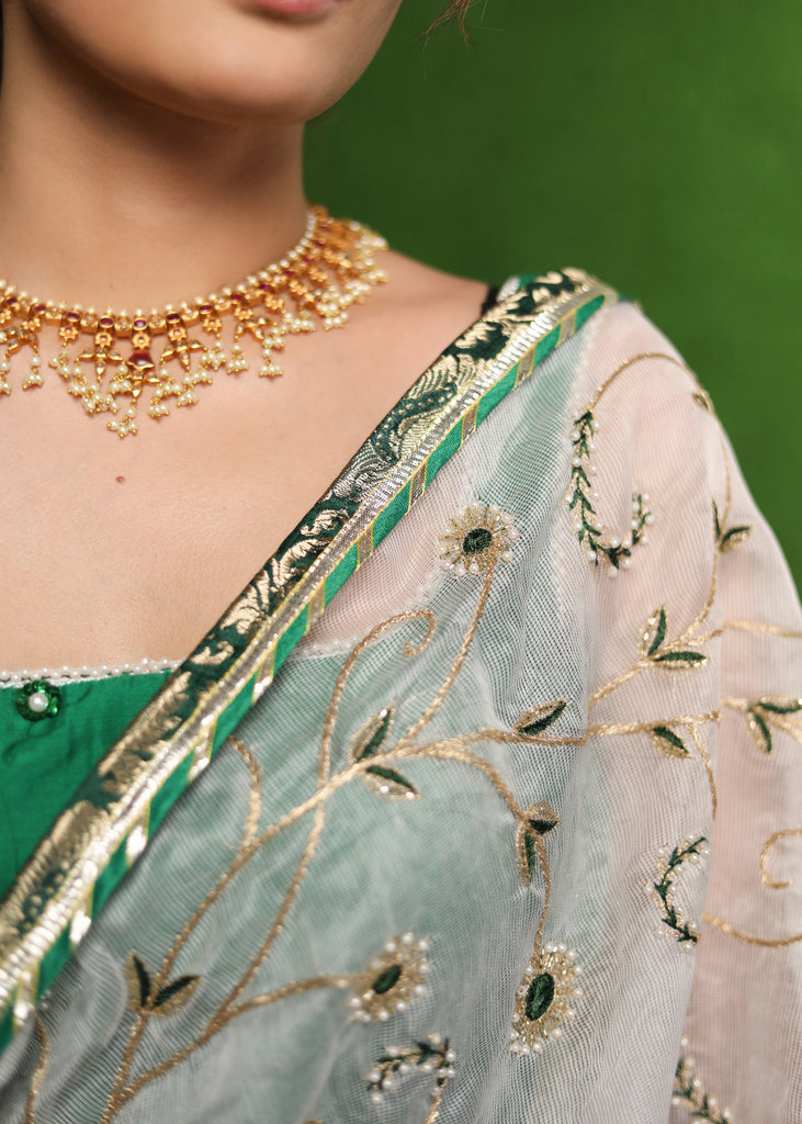 Elegant white saree with delicate hand-embroidery and green Banasari border