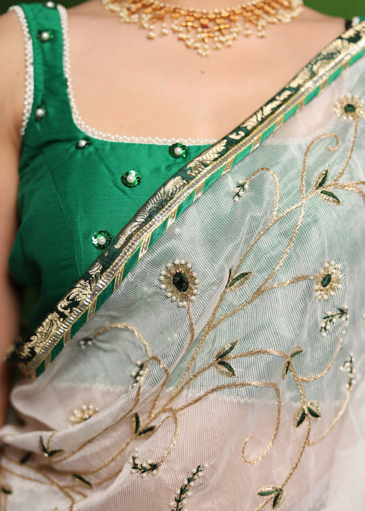 Elegant white saree with delicate hand-embroidery and green Banasari border