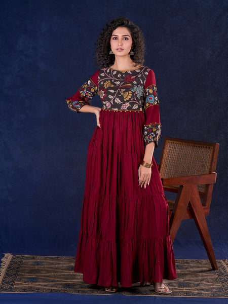 Timeless Maroon Rayon Layered Gown with Gathers and Hand Painted Kalamkari Accents featuring Puffy Sleeves and Delicate Golden Accents