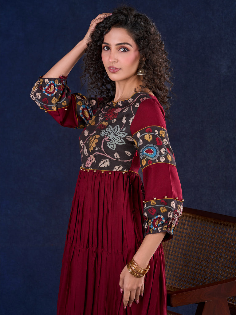 Timeless Maroon Rayon Layered Gown with Gathers and Hand Painted Kalamkari Accents featuring Puffy Sleeves and Delicate Golden Accents