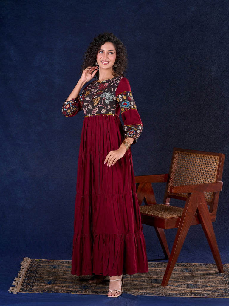 Timeless Maroon Rayon Layered Gown with Gathers and Hand Painted Kalamkari Accents featuring Puffy Sleeves and Delicate Golden Accents