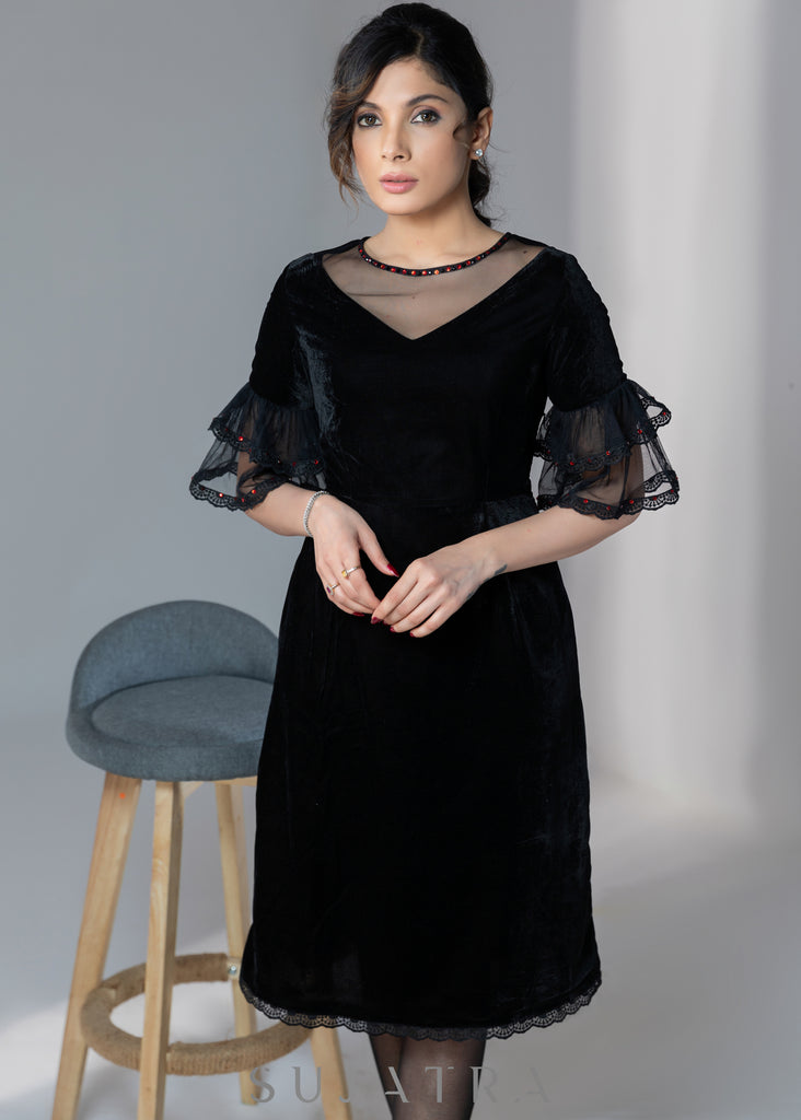 Party wear black velvet dress with net sleeves & red stone work detailing on the neck