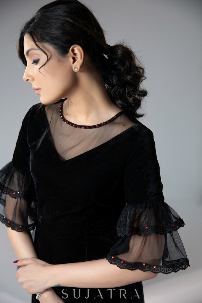 Party wear black velvet dress with net sleeves & red stone work detailing on the neck