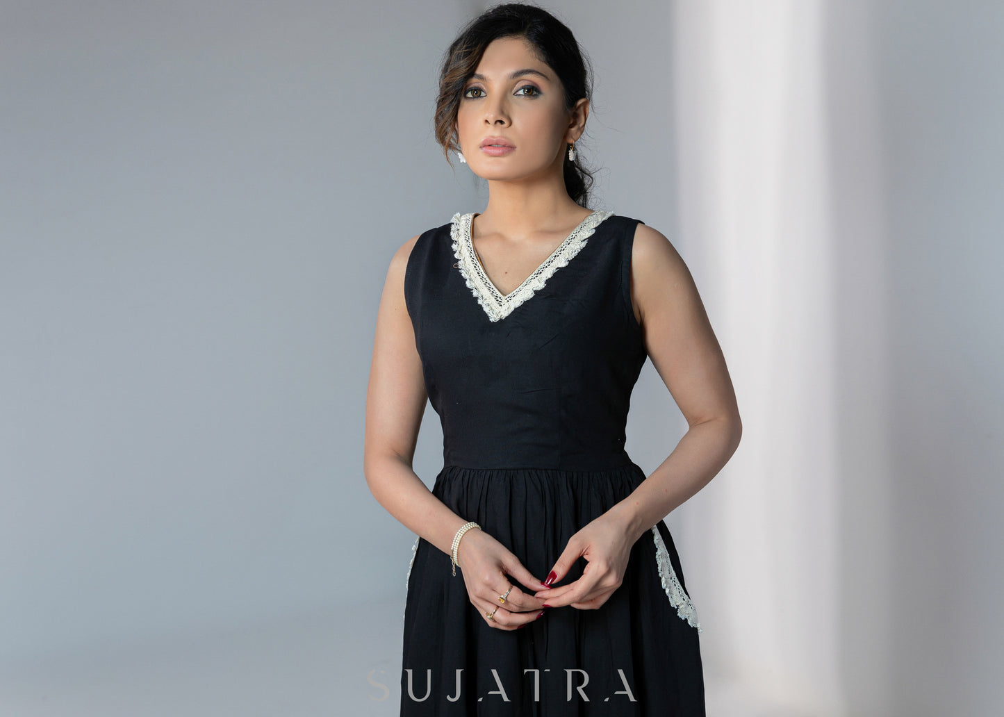 Black sleeveless rayon dress with off white lace detailing on neck and pockets