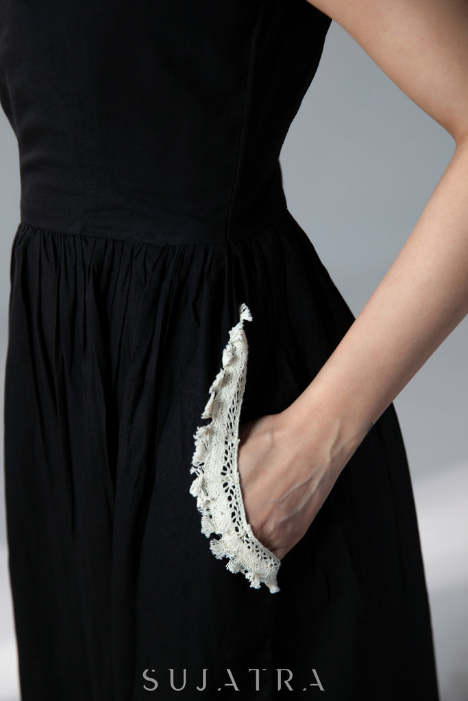 Black sleeveless rayon dress with off white lace detailing on neck and pockets