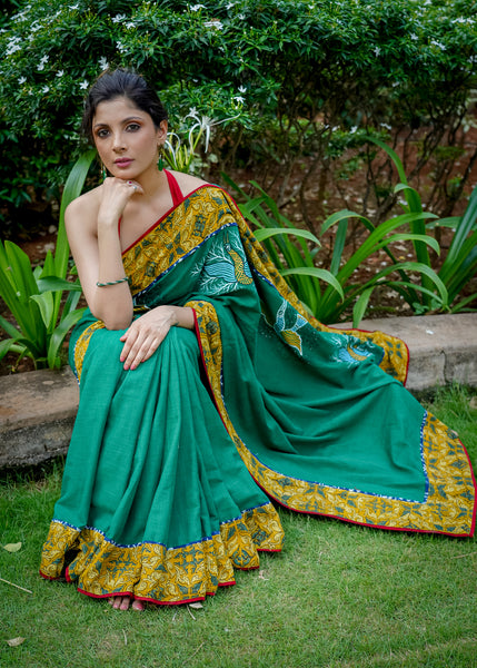 Cotton bottlegreen saree with gond hand painting with Ajrakh border