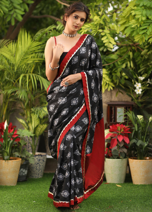 Elegant black printed Cotton saree with maroon Gota Patti border and stone embellishment