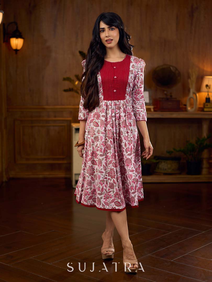 Elegant white floral Jaipuri printed dress with a delicately pintucked red panel, gathered sleeves, and rich red accents.