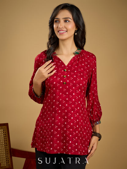 Red rayon bandhani top beautifully combined with classic ikat collar.